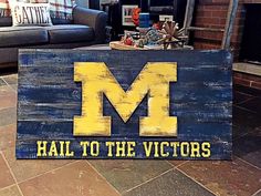 a wooden sign that says hail to the victory on it in front of a couch