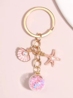 a pink keychain with seashells and starfish on it