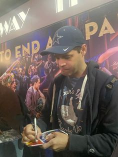 a man signing autographs for fans at an event