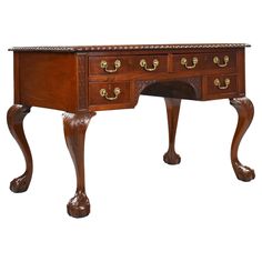 an antique wooden desk with drawers on one side and gold knobs on the other