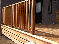 a wooden deck with slats on the top and bottom part, in front of a house