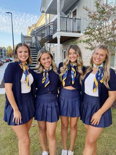 four girls in school uniforms posing for the camera