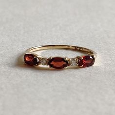 This stunning ring is set in 14k Solid Yellow Gold with Natural Garnet and Diamond with utmost precision. It is a unique statement gemstone ring for nearly every occasion and is completely hassle-free jewelry. ITEM DETAILS: * GEM: Garnet  * GEM SIZE: 3x5mm (3 pc) * GEM SHAPE: Oval * GEM: Diamond (VVS-VS PURITY & I-J color) * GEM SHAPE: Round * Total Gem weight: 0.82 carats * Gold Purity: 14KT (58.33% approx.) * Gold Weight: 1.07 gram * Total Weight of the Ring: 1.24 gram The Gold purity is guaranteed and it comes with authentic 14KT gold hallmark. Since my items are handmade, they are absolutely nickel and lead free. CUSTOMIZATION: * Size Customization is available for this ring and it is available in all ring sizes. Kindly choose your ideal ring size from the drop-down. * Gemstone customi Gold Garnet Jewelry With Accent Stones, Garnet 3 Stone 18k Gold Ring, Vintage Garnet Ring For Gift, Elegant Multi-stone Garnet Rings, Yellow Gold Garnet Multi-stone Ring, Pink Topaz Ring, Garnet Rings With Polished Finish - Fine Jewelry, Garnet And Diamond Ring, January Birthstone Rings