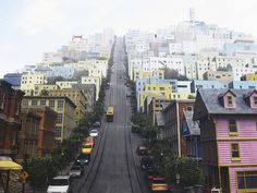 a city street lined with colorful houses and tall buildings