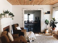 a living room filled with furniture and a fire place under a wooden ceiling mounted flat screen tv