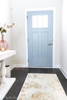 a blue door is in the corner of a room with a rug on the floor