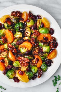 brussel sprouts with oranges and raisins on a white plate