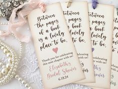 three bookmarks with names on them sitting next to pearls and other items in the background