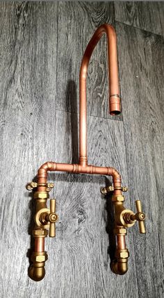 an old fashioned faucet with copper fittings on a wood flooring surface