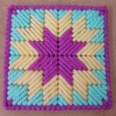 a crocheted square with a purple star on it