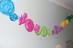 there are many different colored balloons hanging from the wall