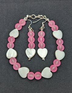 Pink Sea Glass Beaded Bracelet and Earring set with White Heart Shell accent beads. This piece is fitted with silver connectors and a lobster close clasp. Size: 7.5 Inches Pink Sea Glass, Sea Glass Beads, Bracelet And Earring Set, Glass Beaded Bracelet, Pink Sea, Glass Beaded Bracelets, Personalized Bracelets, Shell Beads, White Heart