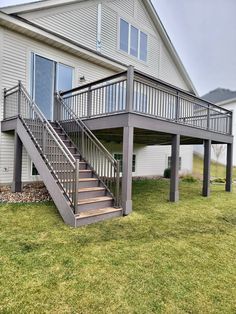 a house with a deck and stairs in the front yard