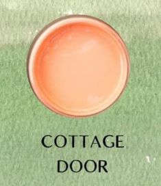 the cover of cottage door, with an orange circle in the center and green grass behind it