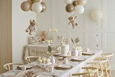 a table set for a baby's first birthday party with balloons and teddy bears