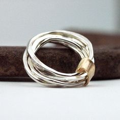 Feb 17, 2016 - Silver stacking rings wrapped in band of 14 karat gold vermeil. A unique jewelry gift she will treasure. Four organic handcrafted artisan stacking sterling silver bands, gently hammered and shaped. A stunning effect for any hand. These are truly organic and different. Completely recycled metal. Modern Silver Ring, Feminine Gifts, Mixed Metal Rings, Unique Jewelry Gifts, Hammered Band, Gold Armband, Uk Post