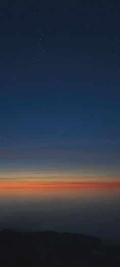 an orange and blue sky with stars above the horizon in the distance, as seen from space