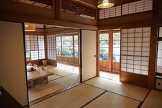 an empty room with wooden doors and windows