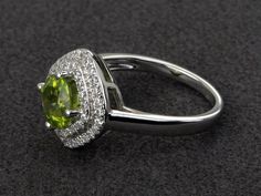 Welcome to my shop, you can find many beautiful gemstone jewelry here, and you also can ask for customized service. Main Stone: natural peridot, round cut 7X7mm, 1.39 carats.Accent Stones: cz Metal: 925 sterling silver plated with rhodium so as to protect the ring from tarnish and keep it shinning. I also can provide metal options such as 14k solid yellow/white/rose goldSetting: prong setting more rings: https://www.etsy.com/shop/XCjewelryStudio?ref=hdr_shop_menuIt's quite comfortable for wearin Green Halo Design Round Jewelry, Peridot Rings With Halo Setting For May Birthstone, Round Peridot Jewelry With Halo Setting, May Birthstone Halo Ring With Halo Setting, Halo Ring With May Birthstone, Wedding Jewelry With Peridot In Halo Setting, Fine Jewelry Diamond Ring With Peridot, Emerald Halo Ring For May Birthstone, Fine Jewelry Peridot Diamond Ring