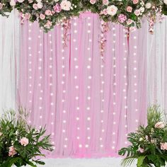 pink backdrop with flowers and greenery on the side for a wedding or party decoration