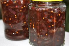 two jars filled with red beans sitting on top of a table