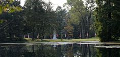 a pond surrounded by trees and flags