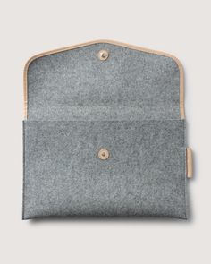 a gray and tan bag with buttons on the front, sitting against a white background