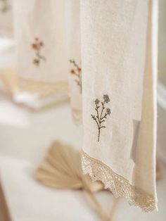 three embroidered towels hanging on a towel rack