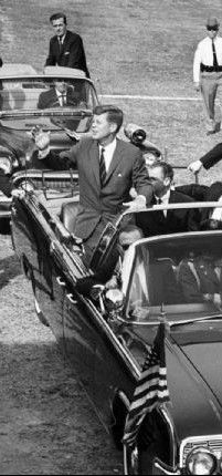 a group of men in suits and ties standing next to a car