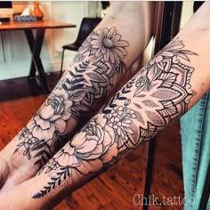 two people with tattoos on their arms and legs, both have flowers in the middle