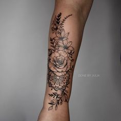 a woman's arm with flowers and leaves tattooed on the side of her leg