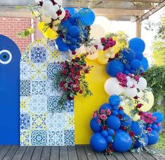 blue and white balloons are hanging on the wall