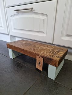 a wooden bench sitting on top of a kitchen floor