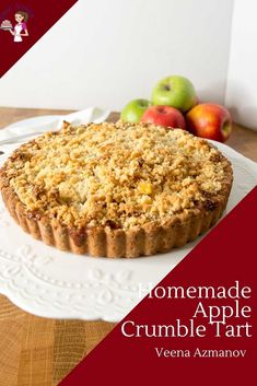 homemade apple crumble tart on a white plate with apples in the back ground