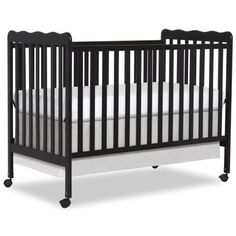 a black crib with white sheets on the bottom and side rails, against a white background