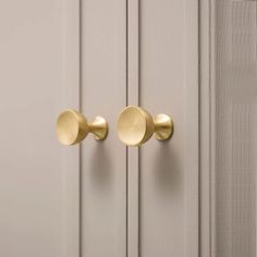 two gold door knobs on the side of a white door