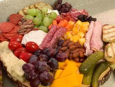 a platter filled with meat, cheese, fruit and nuts