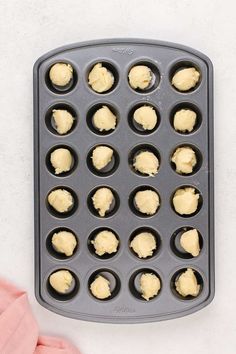 an uncooked muffin tin with several cupcakes in it on a white surface