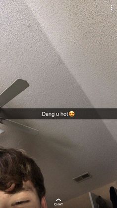 a man standing in front of a ceiling fan with the words dang u hot on it