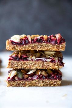 three granola bars stacked on top of each other with fruit and nuts in the middle