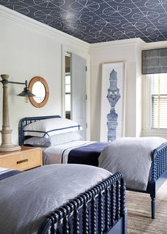 two beds in a bedroom with blue and white decor