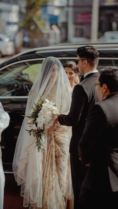 the bride and groom are getting out of their car