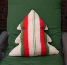 a christmas tree pillow sitting on top of a green chair