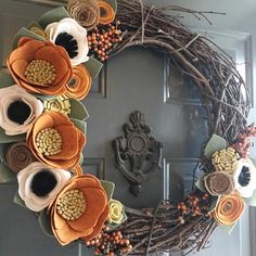 a wreath with flowers and leaves on the front door