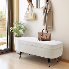 a white bench sitting in front of a window next to a purse and coat rack