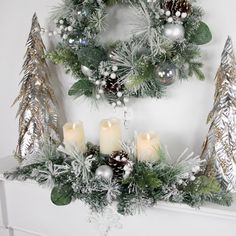 a mantle decorated with silver and white christmas wreaths, pine cones, candles and greenery