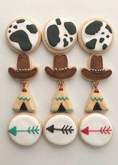 decorated cookies in the shape of cowboy hats and arrows