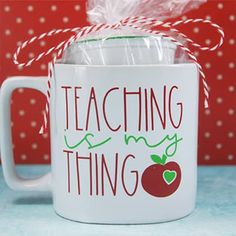 a white coffee mug with an apple on it and the words teaching is my thing