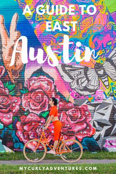 a woman riding her bike in front of a mural with the words, a guide to east