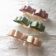 three hair clips with bows and pearls on them